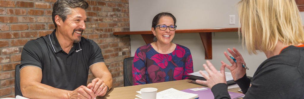 Two people and a guide at desk for a Colorado Homeownership Class