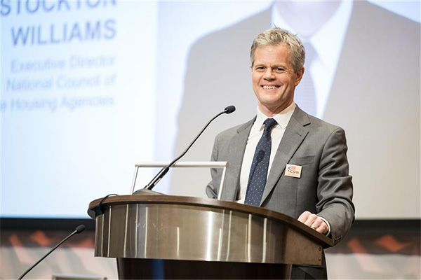 Man smiling behind podium on stage